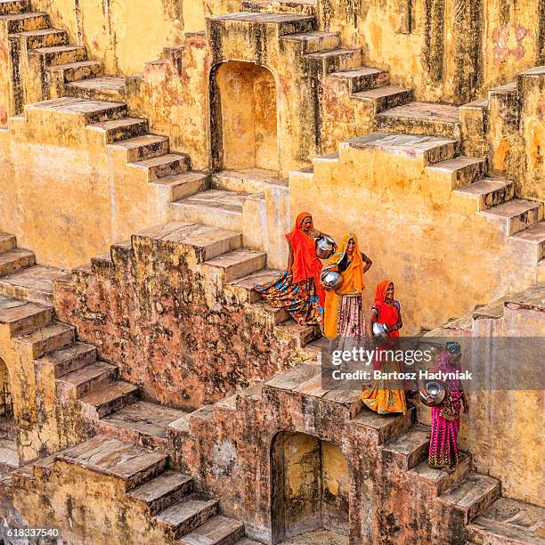 indian women carrying water from stepwell near jaipur - stepwell india stock pictures, royalty-free photos & images