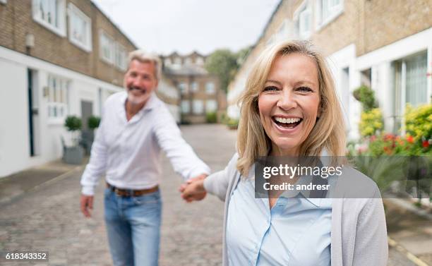 woman pulling her couple on the street - woman dragging stock pictures, royalty-free photos & images