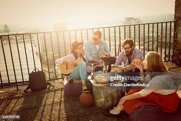 gruppe von freunden, die spaß auf der oberseite der stadt haben - balkon essen stock-fotos und bilder