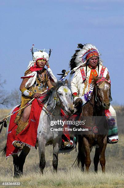 Ethnic First Nation Canadian indians on horseback at Wanuskewin Heritage Park in native costumes. World culture Two men