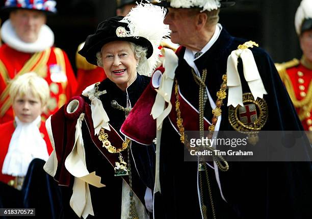 Queen Elizabeth II laughs with Prince Philip, the Duke of Edinburgh at St George's Chapel for the traditional Order of the Garter procession and...
