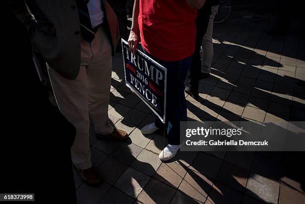 Supporter holds a Trump Pence sign outside the Trump Hotel on October 26, 2016 in Washington, D.C. Republican presidential nominee Donald Trump will...