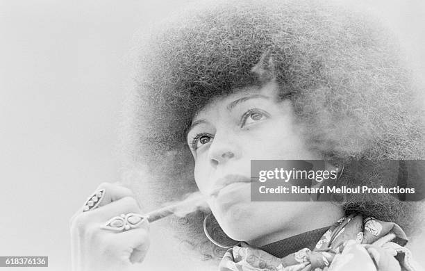 Radical political activist Angela Davis smokes a tobacco pipe in Paris where she is presenting her new book.