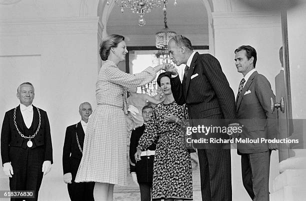 President Valery Giscard d'Estaing kisses the hands of Queen Margrethe II of Denmark as her husband, Prince Henrik looks on. The President and his...