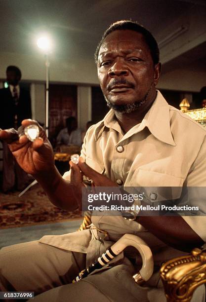 Central African Republic President Jean Bedel Bokassa holding diamonds in 1977. Bokassa came to power through a military coup and later declared...