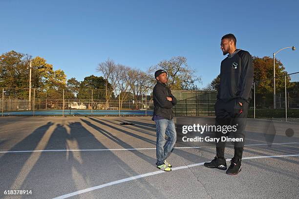 Jabari Parker of the Milwaukee Bucks talks to a young fan after refurbishing an outdoor public basketball court at Mitchell Park and Sherman Park as...