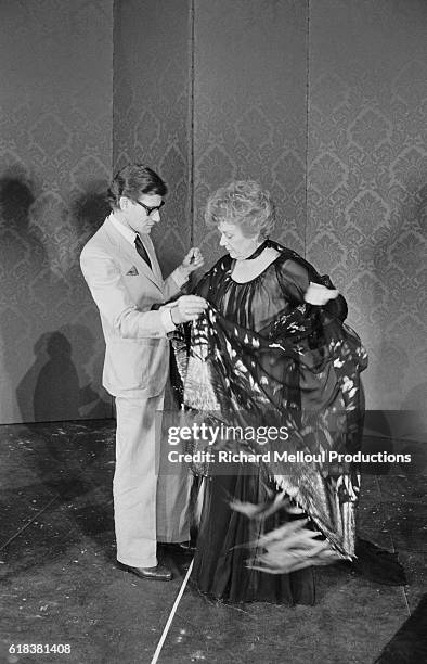 Fashion designer Yves Saint Laurent fits a costume to actress Edwige Feuillere for an upcoming production of Dear Liar. The play, going under the...