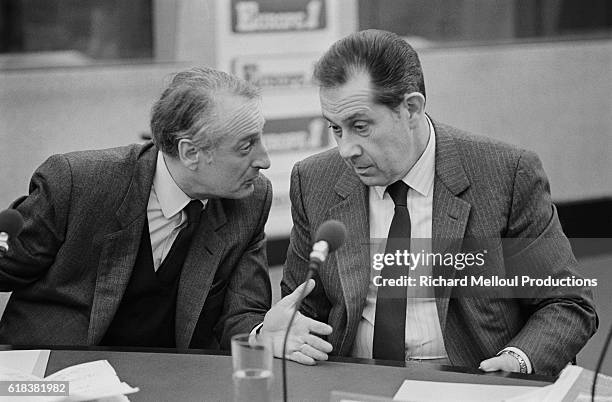 French politician Jean-Francois Deniau leans over to speak to politician Charles Pasqua during a political debate at Europe 1 radio station in Paris.