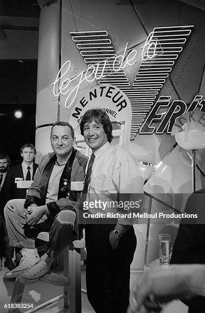 French comedian Coluche next to host Patrick Sabatier on the set of the television show Le Jeu de la Verite at the 38th annual Cannes Film Festival.