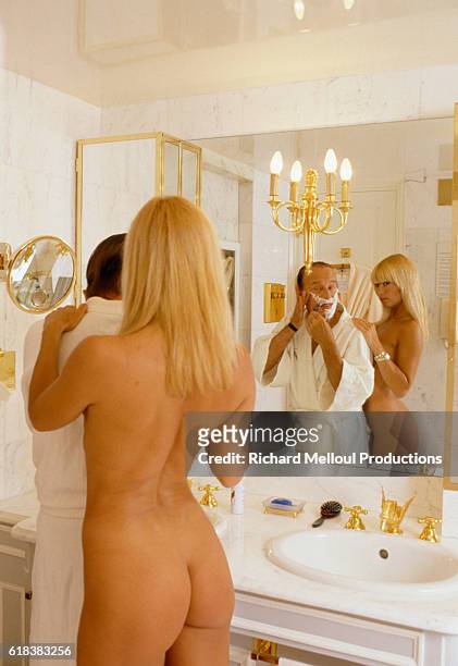 Cabaret owner Alain Bernardin shaves while his fiance, cabaret dancer Lova Moor, stands with him in the nude. Bernardin founded the Crazy Horse...