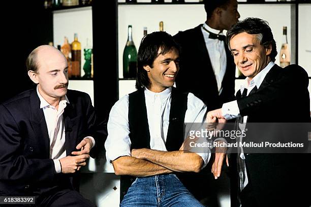 Actor Michel Blanc joins singers Jean-Jacques Goldman and Michel Sardou on the set of the television program Show Sardou.
