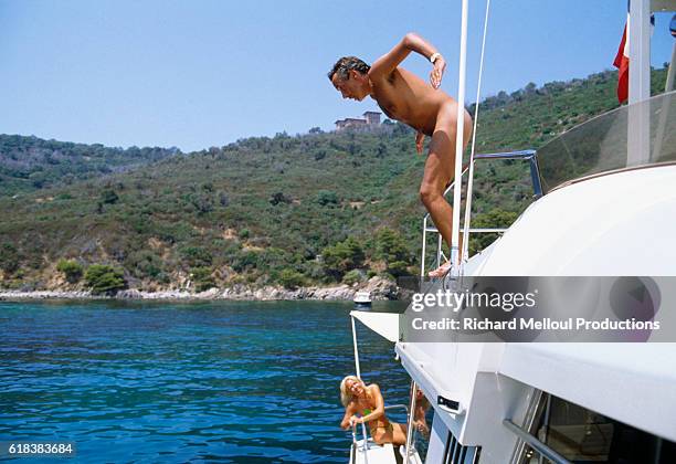 French Singer Michel Sardou dives nude from his boat while on vacation in St.-Tropez, France with his wife Babette .