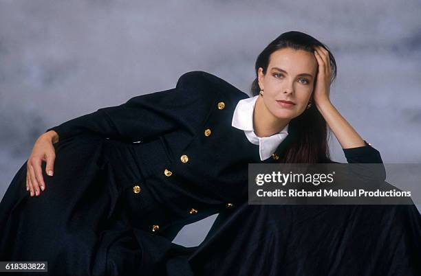 French actress Carole Bouquet wearing a long navy dress. She became a spokeswoman and model for the Chanel fashion house in the 1990s.