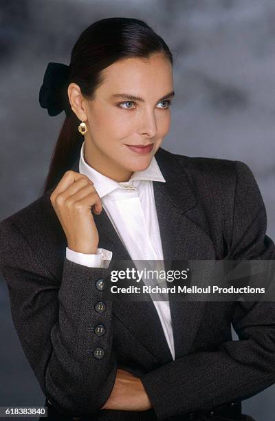 French actress Carole Bouquet wearing a dark gray blazer. She became a spokeswoman and model for the Chanel fashion house in the 1990s.