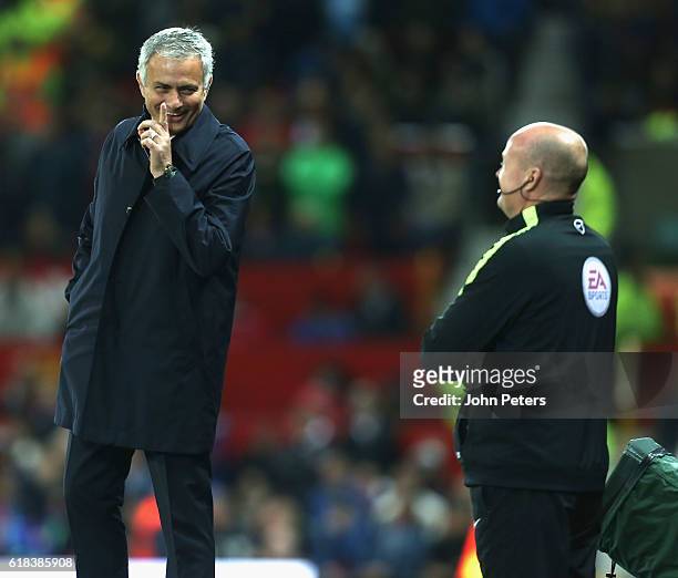 Manager Jose Mourinho of Manchester United shares a joke with fourth official Lee Mason during the EFL Cup Fourth Round match between Manchester...