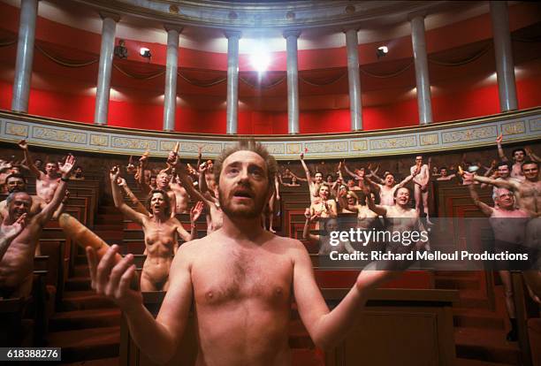 Nude Michel Blanc speaks before an assembly in a scene from the 1988 French film Une Nuit a l'Assemblee Nationale . The movie was written and...