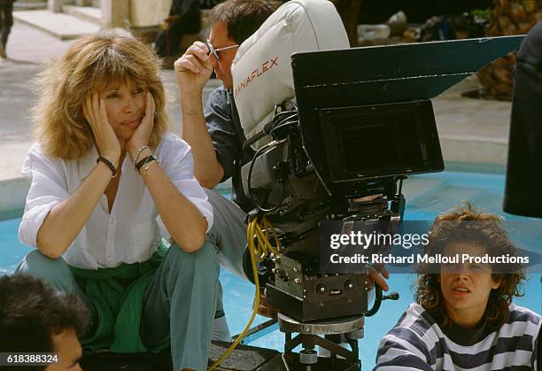 French director Mireille Darc sitting with a film crew during filming of the 1989 film La Barbare. In English the title is The Savage. The film...