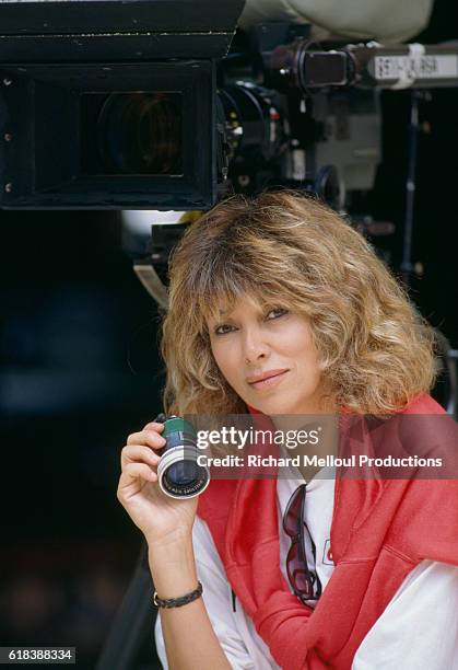 French director Mireille Darc holding a loupe on the set of the 1989 film La Barbare. In English the title is The Savage. The film starred actor...