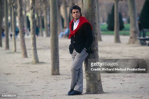 Singer Enrico Macias leans against a tree in Paris.