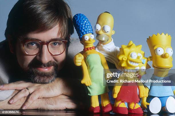 Cartoonist Matt Groening poses with model chaaracters from his animated TV series 'The Simpsons', November 1990.