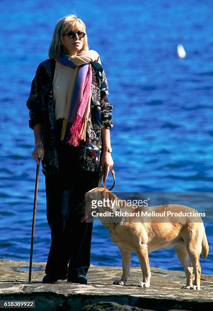Actress Mireille Darc relaxes with her dog on the French Riviera during the filming of her television series Les Coeurs Brules.