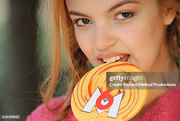 Severine Ferrer is the host of the television shows Hit Dance and Fan de on channel M6 in France. She is eating a yellow lollipop decorated with the...