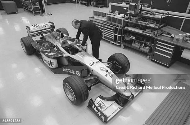 British racecar manager Ron Dennis examines a vehicle at the McLaren Formula 1 workshops in Woking.