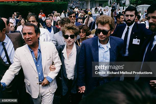 French actors Claude Brasseur, Nathalie Baye and Johnny Hallyday, attend the 37th Cannes Film Festival, to present the movie Detective, directed by...