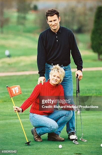 French television presenter Sophie Davant and sports presenter husband Pierre Sled enjoy some spare time on the putting green.