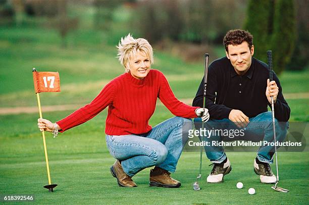 French television presenter Sophie Davant and sports presenter husband Pierre Sled enjoy some spare time on the putting green.