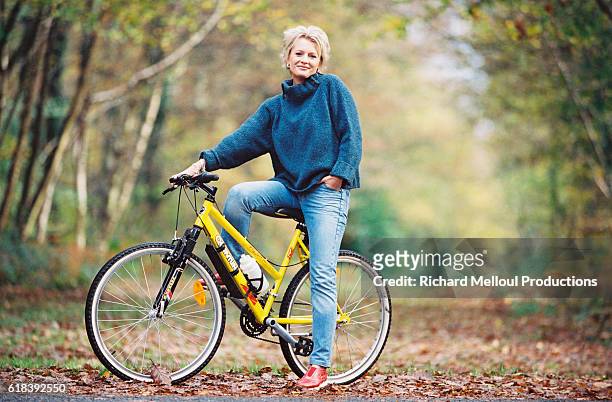 French television presenter Sophie Davant out for a cycle ride in the Normandy countryside.
