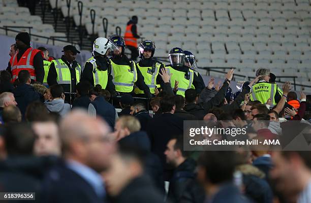 Police officers in riot uniform watch as fans leave during the EFL Cup fourth round match between West Ham and Chelsea at The London Stadium on...