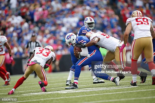 Ahmad Brooks and Rashard Robinson of the San Francisco 49ers tackle EJ Manuel of the Buffalo Bills during the game at New Era Field on October 16,...