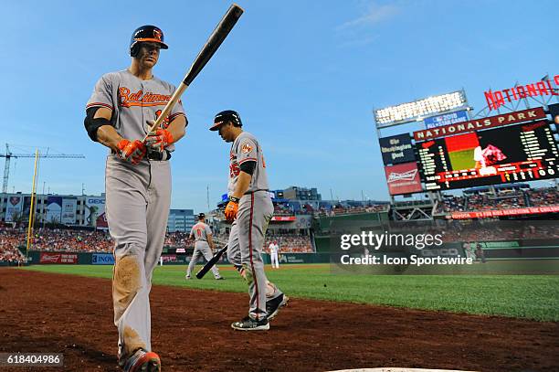 Baltimore Orioles first baseman Chris Davis comes to bat as left fielder Hyun Soo Kim walks back to the dugout at Nationals Park in Washington, D.C.