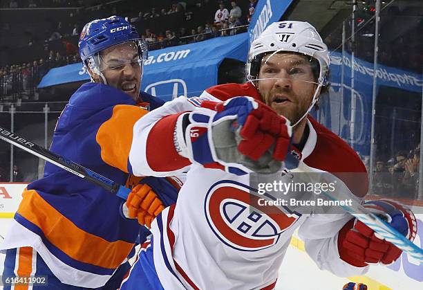 Travis Hamonic of the New York Islanders checks David Desharnais of the Montreal Canadiens during the first period at the Barclays Center on October...