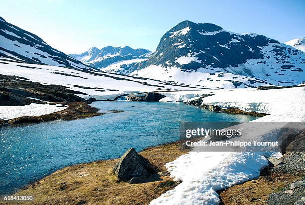 pristine river in a snowy landscape in the scandinavian alps, trollstigen road, norway - spring norway stock pictures, royalty-free photos & images