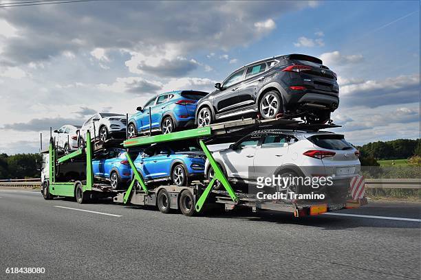autotransporter fährt auf der autobahn - car transporter stock-fotos und bilder