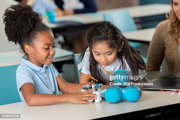 happy elementary schoolgirls work on robotics project - 5-10 2016 stock pictures, royalty-free photos & images