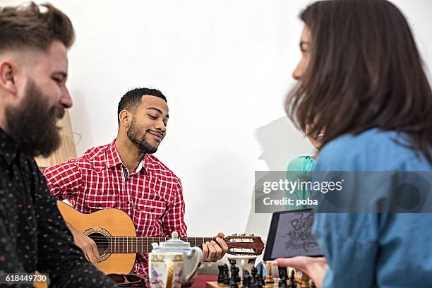 feliz grupo de amigos canta y tocando música juntos - party friends home guitar singers fotografías e imágenes de stock