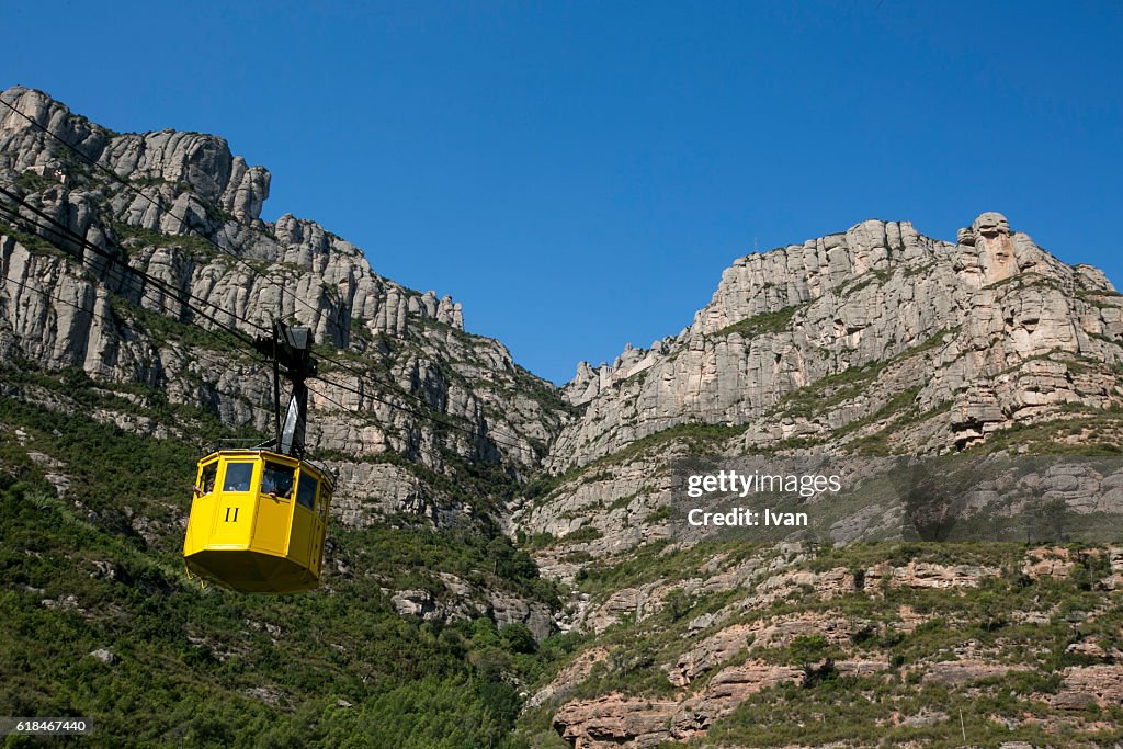 The jagged mountains with yellow cable car (Aeri de Montserrat) in Catalonia, Spain