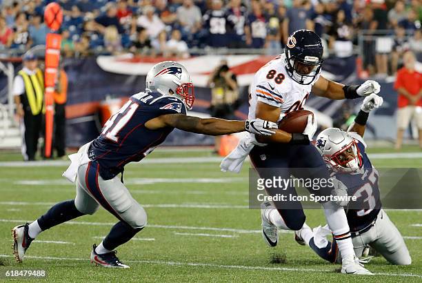Chicago Bears tight end Rob Housler cuts between New England Patriots safety Cedric Thompson and defensive back Jordan Richards . The New England...
