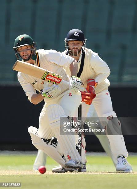 George Bailey of Tasmania bats as wicketkeeper Matthew Wade of Victoria looks on during day three of the Sheffield Shield match between Victoria and...