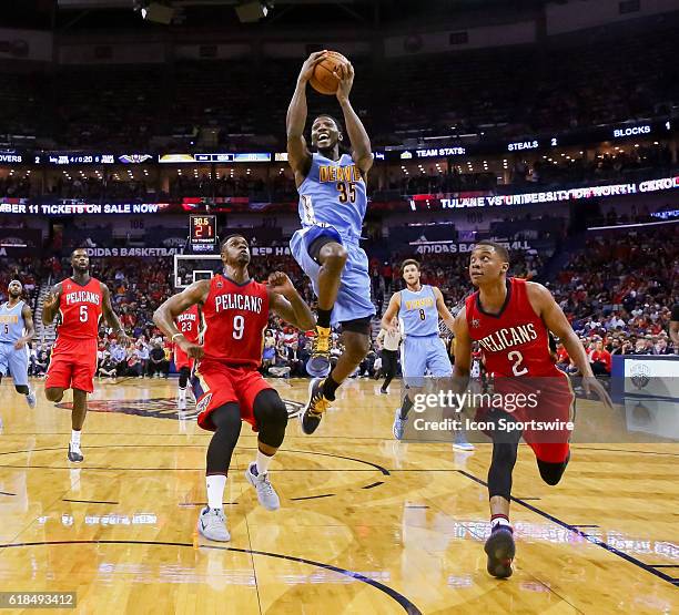 Denver Nuggets forward Kenneth Faried drives to the basket against New Orleans Pelicans guard Tim Frazier and forward Terrence Jones during the game...