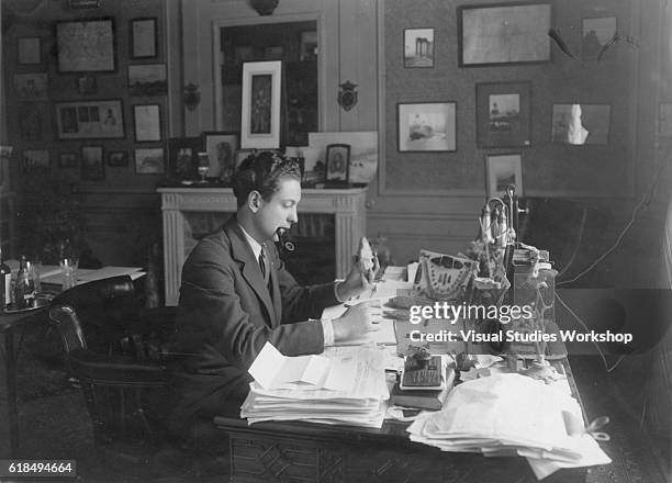 View of American amateur archaeologist Byron Khun de Prorok as he examine a spearhead at his desk, New York, New York, circa 1925.