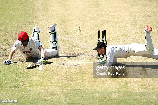 Kane Richardson of the Redbacks dives to into the crease as Sam Whiteman of the Warriors attempts a run-out during day three of the Sheffield Shield...