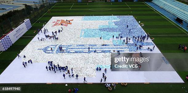 Aerial view of volunteers creating a photo mosaic at Bronze Swallow Terrace on October 26, 2016 in Chongqing, China. 220 volunteers smashed a...