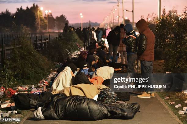 Migrants who slept outside an aid station queue to be assigned to one of the processing centres across France, near the "Jungle" migrant camp in...