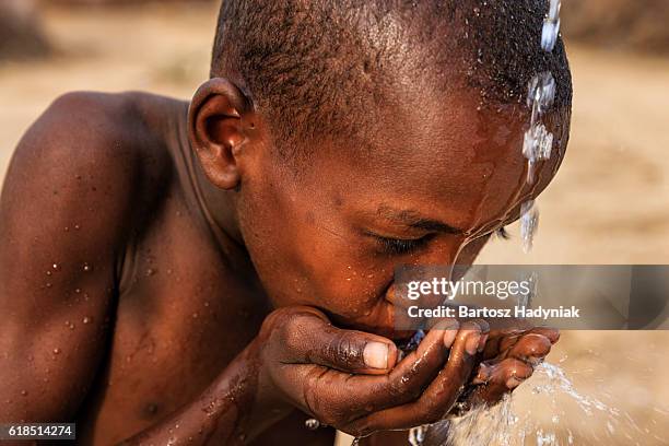 african young boy drinking fresh water on savanna, east africa - kenya stock pictures, royalty-free photos & images