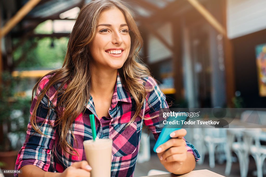 Woman texting at the cafe