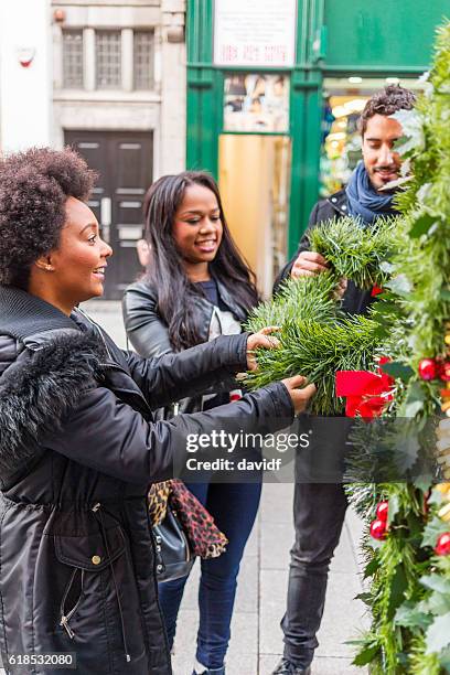 group of friends shopping for a christmas tree - african people buying a christmas tree stockfoto's en -beelden